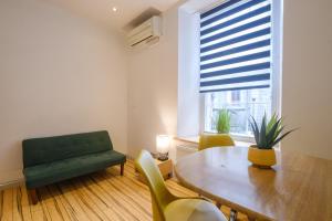 a living room with a table and a green couch at Siberia Bar & Hotel in Aberdeen