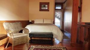 ein Schlafzimmer mit einem Bett, einem Stuhl und einem Fenster in der Unterkunft Seine Boat Inn in Alert Bay