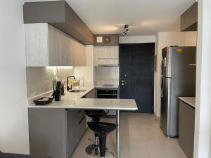 a kitchen with a white counter and a refrigerator at Departamento amoblado, centrico in Temuco