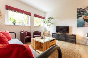 a living room with a couch and a tv at Perfekt für Gruppen, Familien & Geschäftsreisende - Nähe Bamberg & Erlangen in Adelsdorf