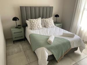 a bedroom with a large bed with white sheets and pillows at 6 Elgin House in Mossel Bay