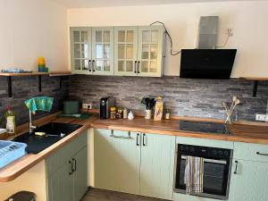 a kitchen with white cabinets and a sink at HofamHohlebach in Neuenburg am Rhein +22 photos