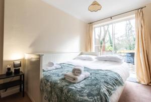 a bedroom with a bed with a towel on it at Spacious and Comfortable Home in Chandlers Ford