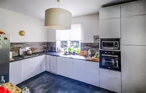 a large kitchen with white cabinets and appliances at Gorgeous Home In Kotkowo With Wi-Fi in Kotkowo