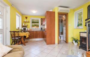 a living room with a table and a kitchen with yellow walls at Nice Home In Brsec With House Sea View in Zagorje