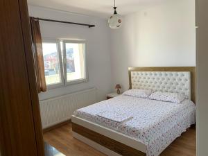 un dormitorio con una cama y una ventana en Pere's Holiday Apartament, en Pogradec