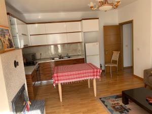 cocina con mesa y mantel rojo en Pere's Holiday Apartament, en Pogradec 13 fotos más