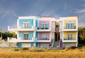 a building with colorful balconies on a beach at Kronos Villas in Kolymvari