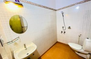 a bathroom with a toilet and a sink and a mirror at Mangosteen villa in Ernakulam