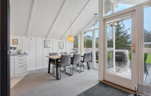 a dining room with a table and chairs and windows at Amazing Home In Tarm With Wifi in Tarm