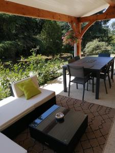 a patio with a table and a table and chairs at L'Esquiròu du Sécadou in Castels