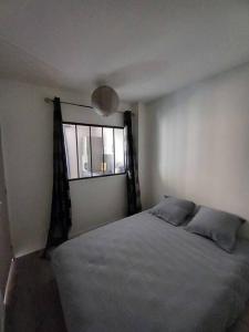a bedroom with a bed and a window at Appart Distillerie in Narbonne