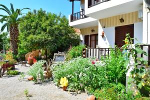 um jardim em frente a uma casa com flores em Zaira Studios em Skala Eresou