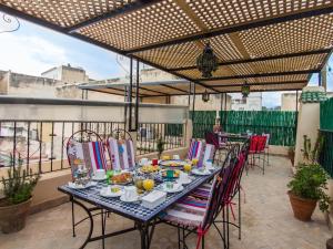 una mesa y sillas en un patio al aire libre en Casa Aya Medina, en Fez
