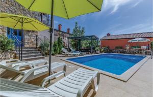 a swimming pool with chairs and umbrellas next to a pool at Holiday Home Kamena Vas Kamena Vas in Karojba