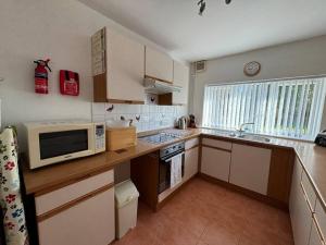 a small kitchen with a microwave and a sink at West Down in Glastonbury +4 photos