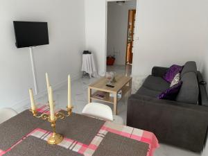 a living room with a couch and a table with candles at Flosoleil in Beauvais