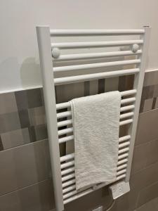 a towel rack in a bathroom with a white towel at La Petite Bourgeoise in Croisilles