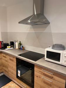 a kitchen with a microwave and a stove top oven at La Petite Bourgeoise in Croisilles