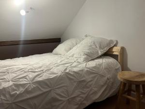 an unmade bed in a room with a table at La Petite Bourgeoise in Croisilles