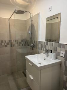 a white bathroom with a sink and a shower at La Petite Bourgeoise in Croisilles +17 photos