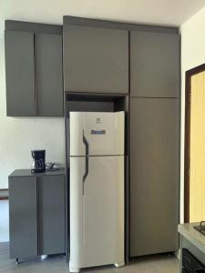 a white refrigerator in a kitchen with cabinets at Cana Caiana Casa in Paraty