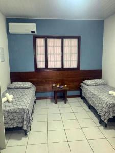 a hospital room with two beds and a table at Cana Caiana Casa in Paraty