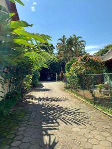 a cobblestone road with plants and a fence at Cana Caiana Casa in Paraty