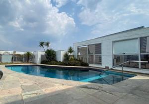 a swimming pool in front of a house at lindo flat no mercure in Manaus