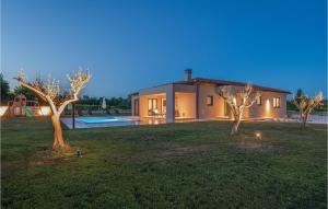 een huis met een tuin met bomen ervoor bij Villa Vitis Vitae in Peresiji