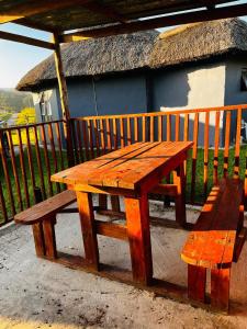 - une table de pique-nique en bois et un banc sur le balcon dans l'établissement Mnceba Mbotyi cottage, à Lusikisiki