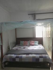 a bedroom with a bunk bed with a canopy at Sour sop Guest House in Kampala