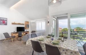 a dining room with a table and a living room at Awesome Apartment In Vrbnik With Wifi in Vrbnik