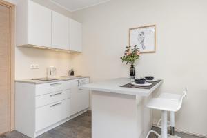 a kitchen with white cabinets and a white counter top at Aisa Studio37 in Pärnu