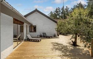 a wooden deck with two chairs on a house at Gorgeous Home In Nørre Nebel With Wifi in Nørre Nebel +16 photos