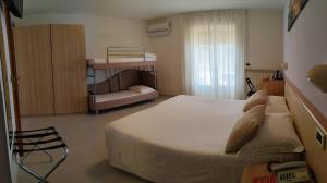 ein Schlafzimmer mit einem großen weißen Bett und einem Fenster in der Unterkunft Hotel Eliani in Grado