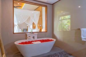 乌布Sawitri Anandhita Luxury Villas的浴室配有带窗户的大型白色浴缸