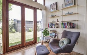 a living room with a chair and a book shelf at Four-Bedroom Holiday Home In Borkop in Børkop