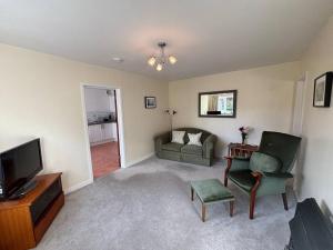 Una sala de estar con un sofá y un televisor. en East Down, en Glastonbury