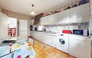 a kitchen with a washing machine and a table at Cozy Home In Saint-Georges-De-Didonne in Saint-Georges-de-Didonne +27 photos