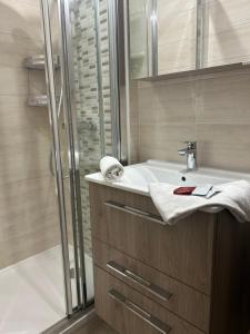 a bathroom with a shower and a white sink at Le cocon de la Garrigue in Cap d'Agde +30 photos