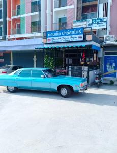 a blue car parked in front of a building at Swiss Style Guesthouse in Cha Am +12 photos