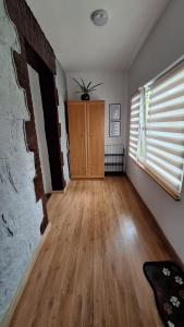 an empty living room with a brick wall and wooden floors at Apartamenty Droga na Śnieżkę in Karpacz