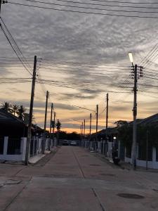 タラーンにあるRami Naiyangの電柱と夕日のある空っぽの通り