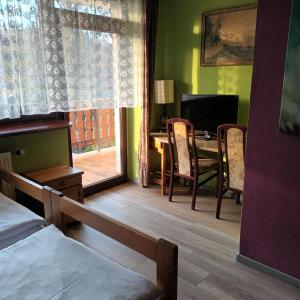 a bedroom with a bed and a desk and a window at Usługi hotelarskie Karpacz in Karpacz