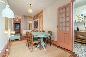 ein Esszimmer mit Tisch und Stühlen und einer Tür in der Unterkunft Casa do Alfaiate Séc XIX in Porto