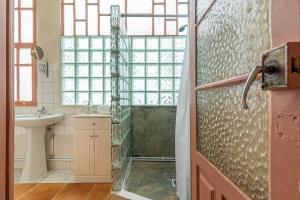 ein Badezimmer mit Glasdusche und Waschbecken in der Unterkunft Casa do Alfaiate Séc XIX in Porto