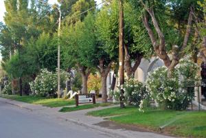 a park with a bench on the side of a street at Ruca Hue in Puerto Madryn