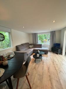 a living room with a couch and a table at Bosrijk chalet Veranda, Honden in Doornspijk +25 photos