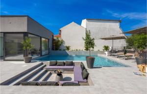 a swimming pool with purple loungers next to a house at Villa Opal in Zadar